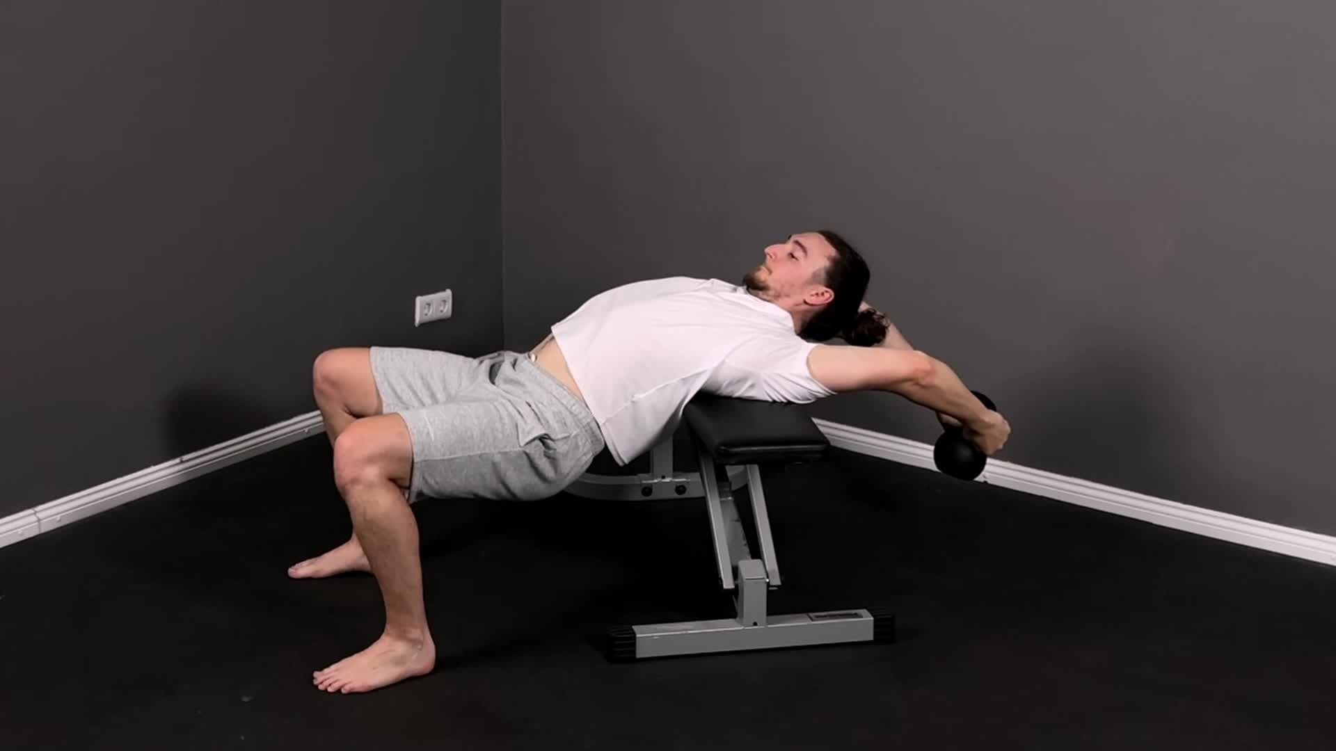Männlicher Athlet beim tiefen Overhead-Schulter-Mobilitätsdrill mit vollständig gestreckten Armen in einem minimalistischen Gym